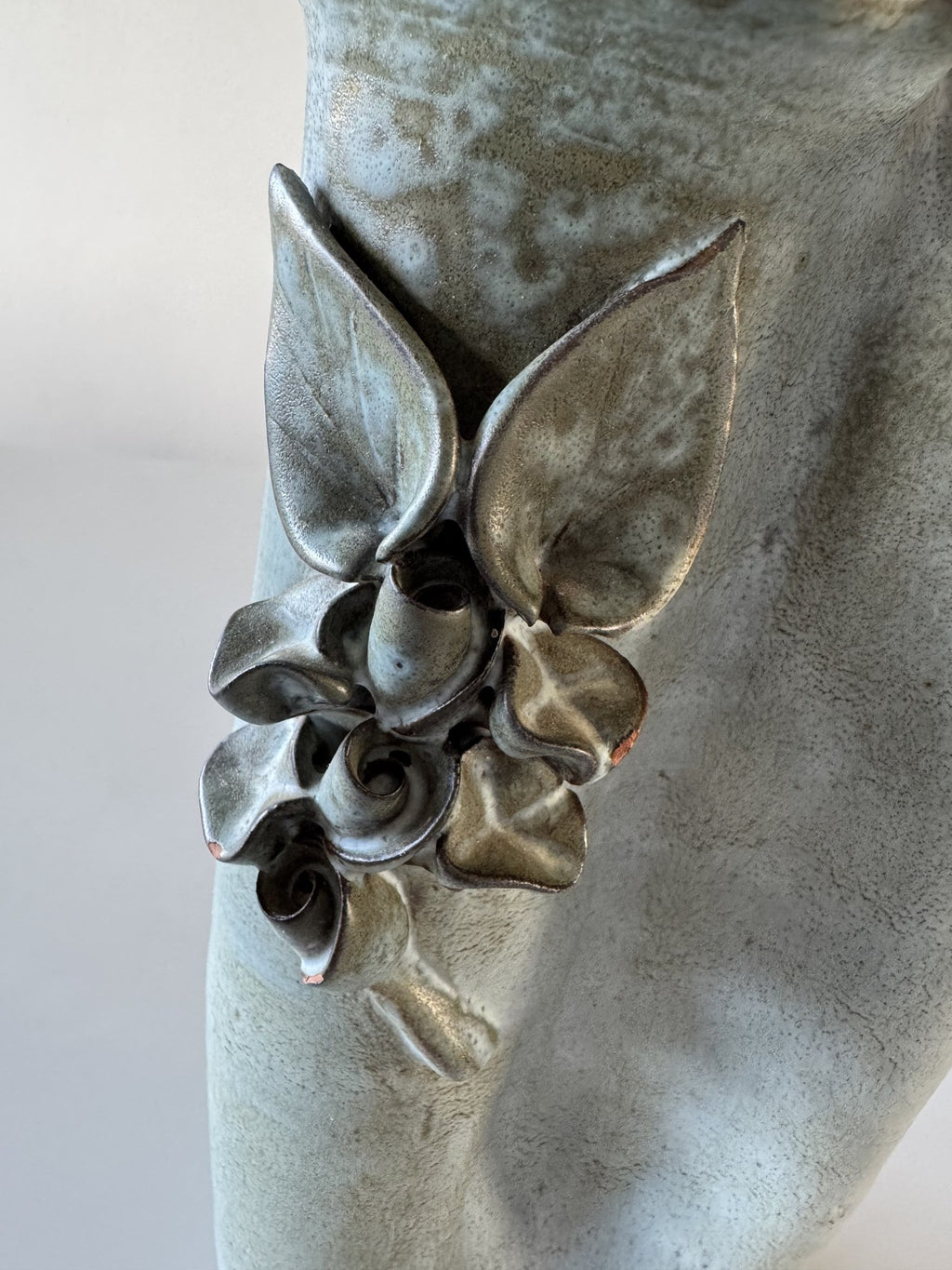 Lyseblå vase med blomsterrelief
